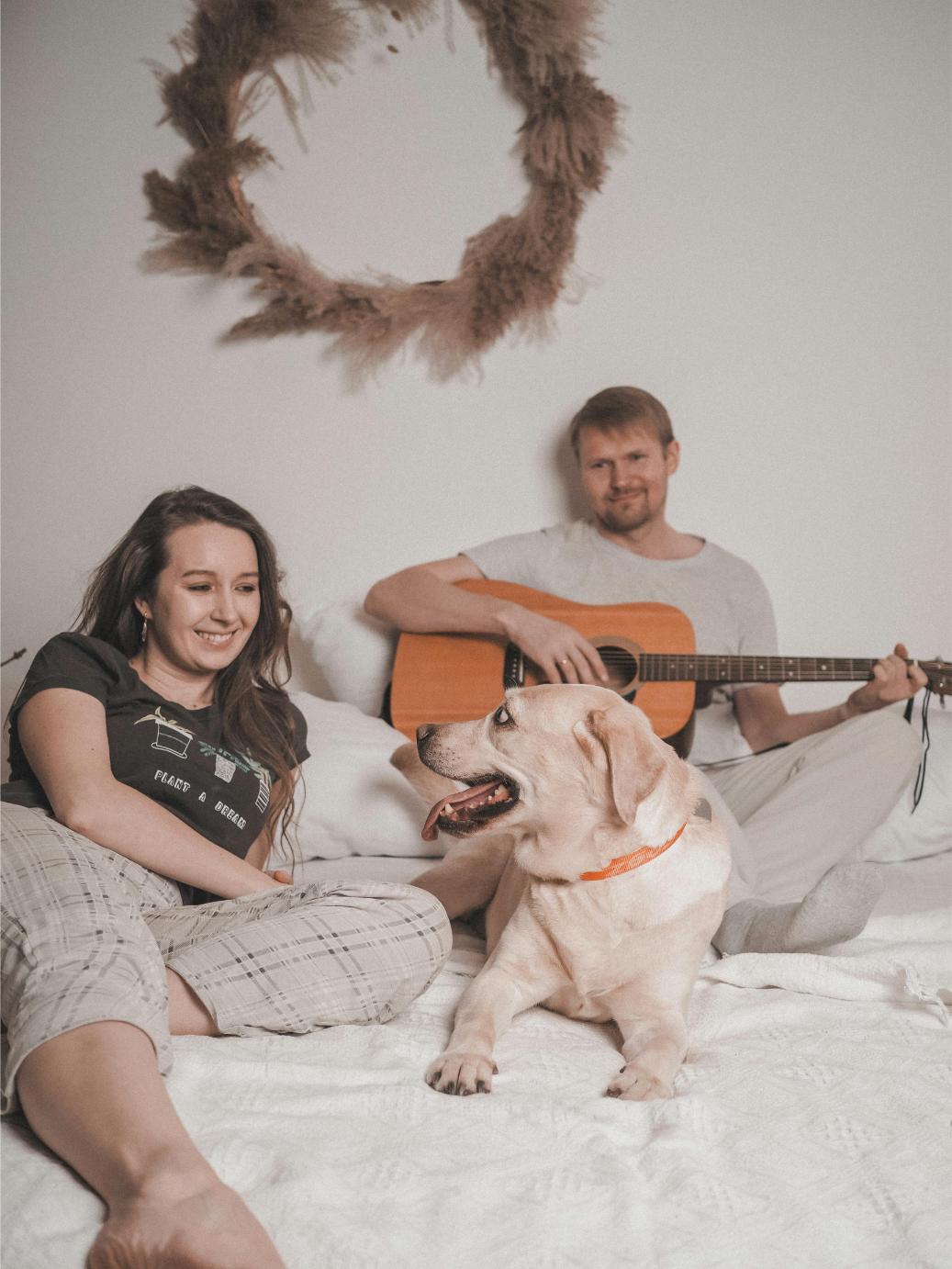 Pareja con su perro tocando música para perros con guitarra